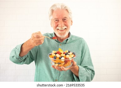 Portrait of smiling senior white-haired man ready to eat a salad of fresh summer fruits. Breakfast or lunch time, healthy eating - Powered by Shutterstock