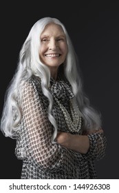 Portrait Of A Smiling Senior Woman With Long Gray Hair Against Black Background