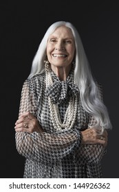 Portrait Of A Smiling Senior Woman With Long Gray Hair Against Black Background