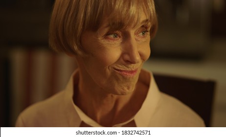 Portrait Of Smiling Senior Woman Making Toast During Festive Dinner. Mature Lady Talking With Family. Older Woman Holding Glass Of Wine. Closeup Senior Woman With Stylish Hairstyle