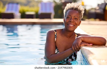 Portrait Of Smiling Senior Woman On Summer Holiday Relaxing In Swimming Pool - Powered by Shutterstock