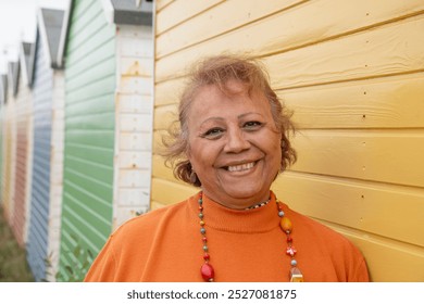 Portrait of smiling senior woman standing by beach hut - Powered by Shutterstock