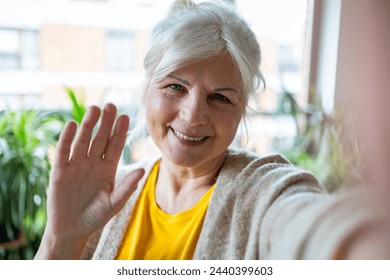 Portrait of smiling senior woman taking selfie with mobile phone at home
 - Powered by Shutterstock