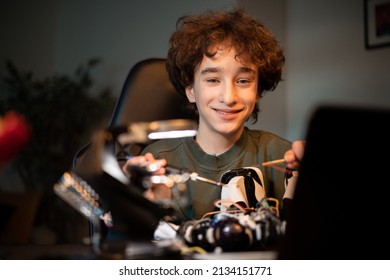 Portrait Of Smiling Smart Boy Passionate About Electronics, Repairing Electric Robot, Child Solders Broken Wires, Control Cables