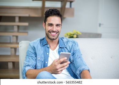 Portrait Of Smiling Smart Man Using Smartphone At Home