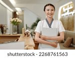 Portrait of smiling spa salon receptionist holding folder