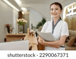 Portrait of smiling spa salon receptionist with documents folder