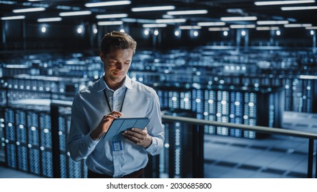Portrait of Smiling IT Specialist Using Tablet Computer in Data Center. Big Server Farm Cloud Computing Facility with Male Maintenance Administrator Working. Cyber Security, e-Business.