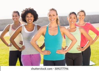 Portrait of smiling sporty women with hands on hips in parkland - Shutterstock ID 309277796