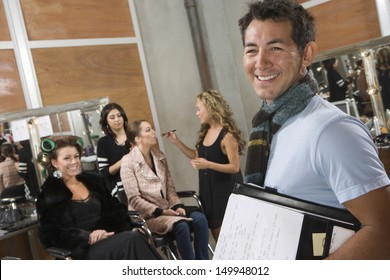 Portrait Of A Smiling Stage Manager With Models In Dressing Room