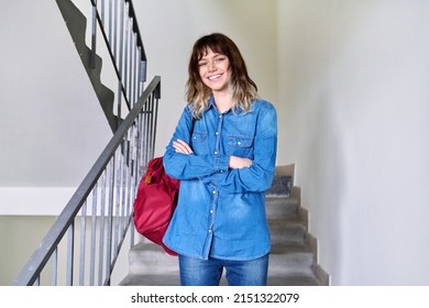 Portrait Of Smiling Student Girl With Backpack On The Stairs Inside Building