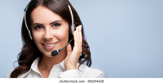 Portrait Of Smiling Support Female Phone Operator In Headset, Against Grey Background. Consulting And Assistance Service Call Center.