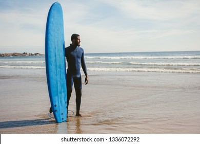 Portrait of smiling  surfer man with surf board on the beach. Mixed African race black skin and beard. Summer sport activity  - Powered by Shutterstock