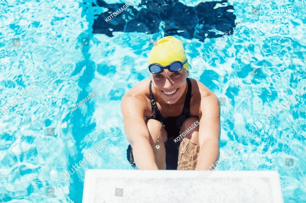 Portrait Of Smiling Swimmer Poised At Starting Block Sports ...