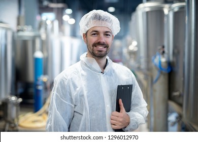 Portrait of smiling technologist in industrial plant.