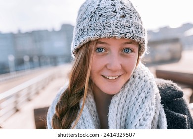 Portrait of smiling teenage girl wearing woolly hat and scarf - Powered by Shutterstock