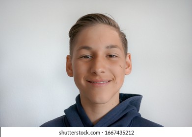 Portrait of smiling teenager boy on white background wearing hoodie