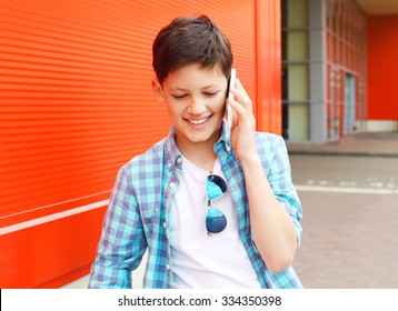 Portrait Smiling Teenager Boy Talking On The Phone In City