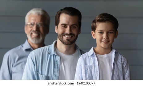 Portrait Of Smiling Three Generations Of Caucasian Men Isolated On Grey Background Look At Camera. Happy Little Boy Son With Young 30s Father And Older 60s Grandfather Show Family Unity And Bonding.