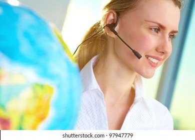 Portrait of smiling tour agent with headset consulting client online