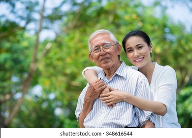 Portrait of smiling Vietnamese woman hugging her father