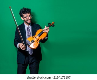 Portrait of a smiling violinist man isolated, Smiling violinist man looking at camera and holding his violin, Violinist man concept on isolated background