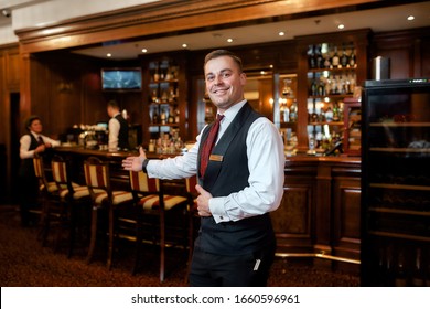 Portrait of smiling waiter welcoming guests in hotel restaurant. Horizontal shot - Powered by Shutterstock