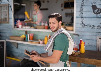 Portrait of smiling waiter writing on slate - Powered by Shutterstock