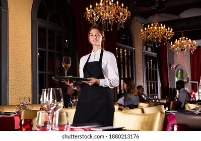 Portrait Of Smiling Waitress With Tray At Luxury Restaurant