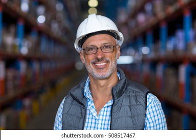 Portrait Of Smiling Warehouse Worker Wearing Hard Hat In Warehouse