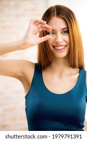 Portrait Of Smiling Woman Covering Her Eye, Looking Through Omega 3 Fish Oil Capsule. Beautiful Girl In Casual Blue Dress - Health Care And Medical Concept. Dha Pill Tablet. Salmon Fat. Vitamin.