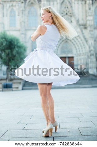 portrait of smiling woman in the dress moving at the street