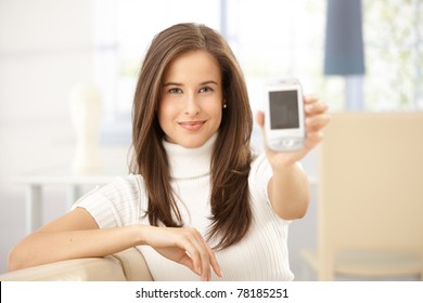 Portrait Of Smiling Woman Holding Cellphone Up To Camera.?