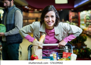 Portrait Of Smiling Woman Holding A Trolley In Organic Section Of Supermarket