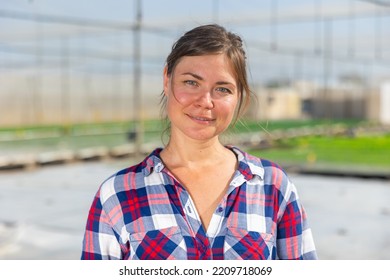 Portrait Of Smiling Woman Horticulturist Standing In Hothouse