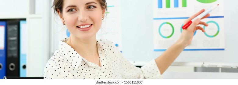 Portrait Of Smiling Woman Indicating Financial Statements To Board Directors. Young Businesswoman At Seminar. Company And Business Meeting Concept. Blurred Background