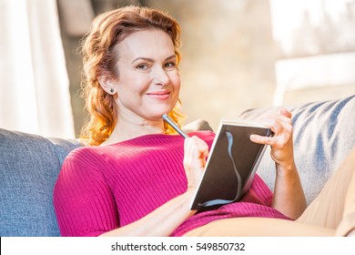Portrait of smiling woman making notes in notepad