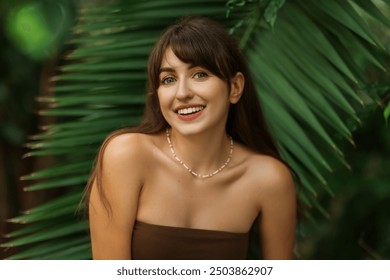 Portrait of smiling woman near palm leaves outdoors - Powered by Shutterstock