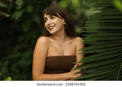 Portrait of smiling woman near palm leaves outdoors - Powered by Shutterstock