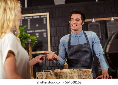 Portrait Of A Smiling Woman Paying In Cash At The Coffee Shop Counter