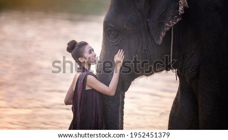 Portrait Of Smiling Woman Standing With Elephant In Thailand.