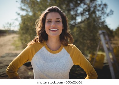 Portrait of smiling woman standing at olive farm on sunny day - Powered by Shutterstock