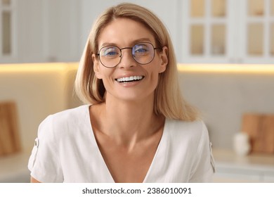 Portrait of smiling woman with stylish glasses in kitchen - Powered by Shutterstock