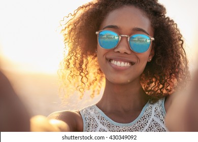 Portrait of a smiling woman wearing sunglasses at the beach
