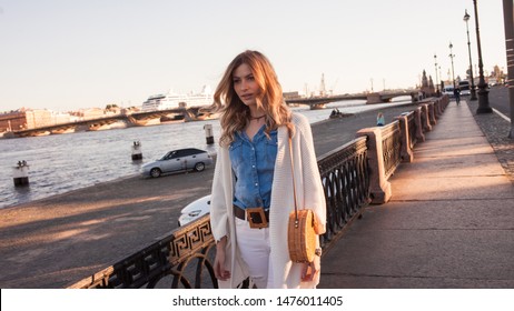 Portrait of smiling woman in a white cardigan. Laughing girl on the background of street, freedom and happiness