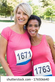 Portrait of smiling women participating in breast cancer marathon at park