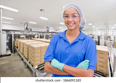 Portrait of smiling worker at food packaging production line - Shutterstock ID 1866091183