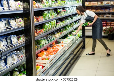 Portrait Of A Smiling Worker Taking A Vegetables In Supermarket