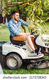 Portrait Of Smiling Worker Using Lawn Tractor For Cutting Grass