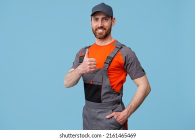 Portrait of smiling workerman In uniform showing thumbs up and looking at camera - Shutterstock ID 2161465469